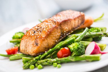 Asparagos brokoli havuç domates turp yeşil fasulye ve bezelye ile kavrulmuş somon steak. Balık unu taze sebze ile
