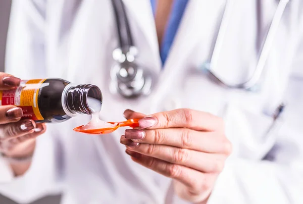 Händerna på ung kvinna läkare hälla läkemedel sirap på sked — Stockfoto
