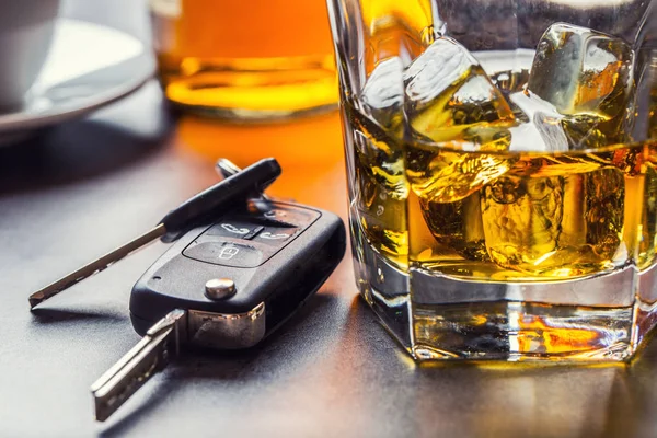 Llaves de coche y vaso de alcohol en la mesa . — Foto de Stock