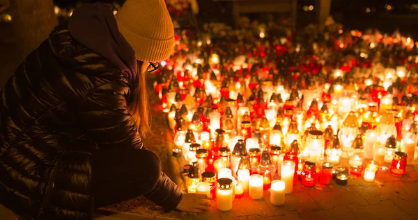 Ein junges Mädchen zündet am Allerheiligentag eine Kerze an — Stockfoto