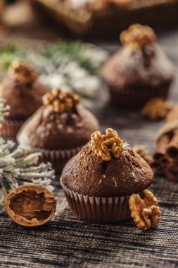 Noel çikolatalı lezzetli kekler üzerine şeker tozu ve ceviz serpiştirilmiş.