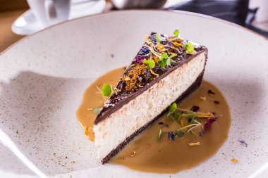 Çiçekli cheesecake ve tabakta karamel sosu