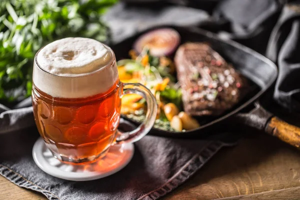 Vaso de cerveza roja en pub o restavurant sobre mesa con comida delicoius — Foto de Stock