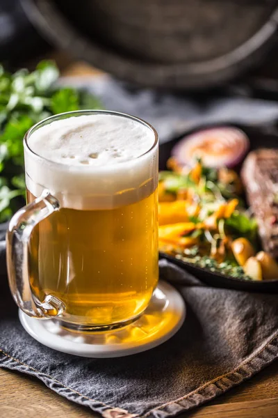 Vaso de cerveza ligera en pub o restavurant sobre mesa con comida delicoius — Foto de Stock