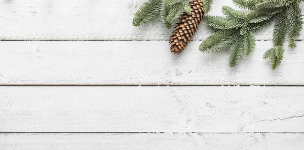 Різдвяний фон гілочки і сосновий конус на дерев'яному фоні - вид зверху — стокове фото