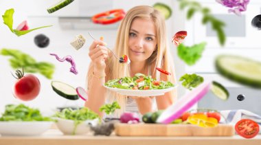 Genç mutlu sarışın kız arugula spinac sağlıklı salata yeme