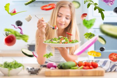 Genç mutlu sarışın kız arugula spinac sağlıklı salata yeme