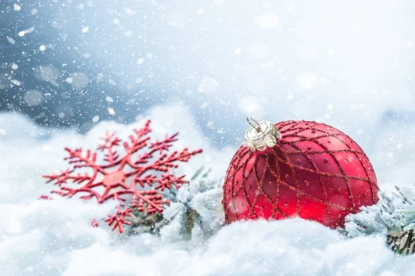 Röd julboll på snö med gran grenar. God jul-konceptet — Stockfoto
