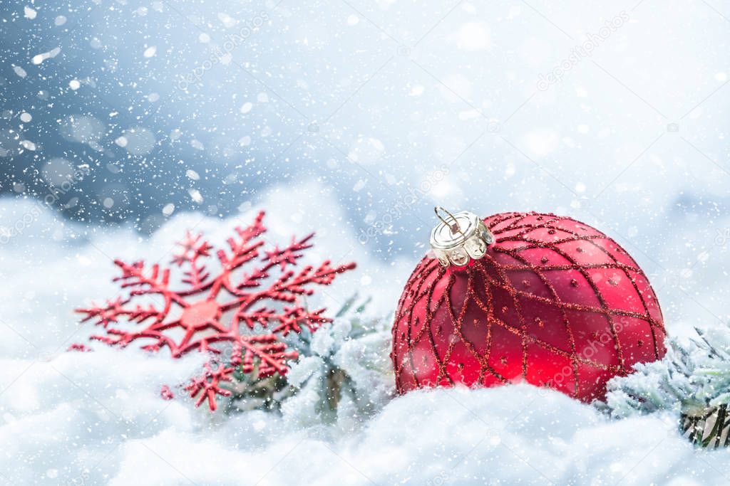 Red christmas ball on snow with fir branches. Merry Xmas concept