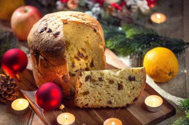 Noel sofrasında nefis panettone. Zeka süslemeleri, gelişmekte olan çelenkler ve mumlar.