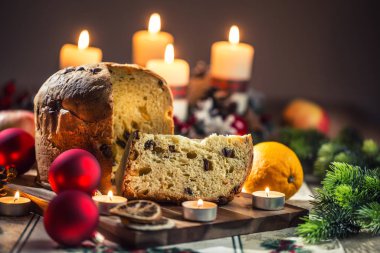 Noel sofrasında nefis panettone. Zeka süslemeleri, gelişmekte olan çelenkler ve mumlar.
