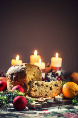 Noel sofrasında nefis panettone. Zeka süslemeleri, gelişmekte olan çelenkler ve mumlar.