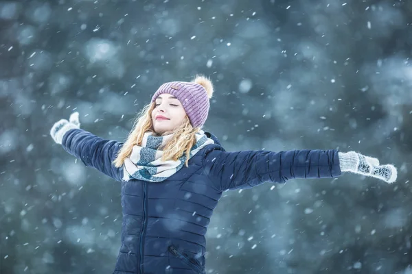 Happy young woman in warm clothing enjoying winter snowfall — 스톡 사진