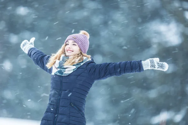 Happy young woman in warm clothing enjoying winter snowfall — 스톡 사진