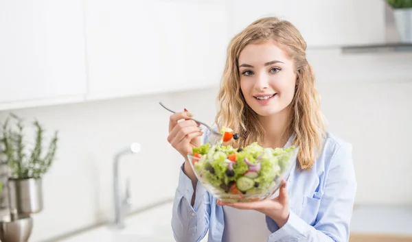 Jovem menina loira feliz comer salada saudável — Fotografia de Stock