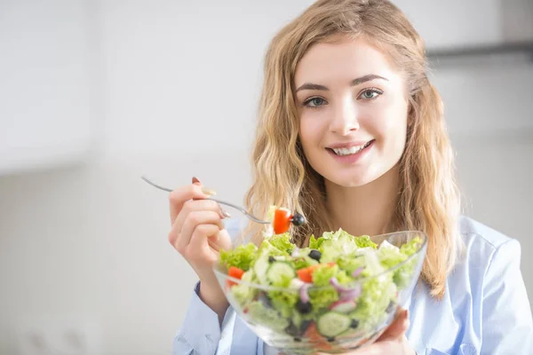 Young happy blonde girl eating healthy salad — Stock Photo, Image
