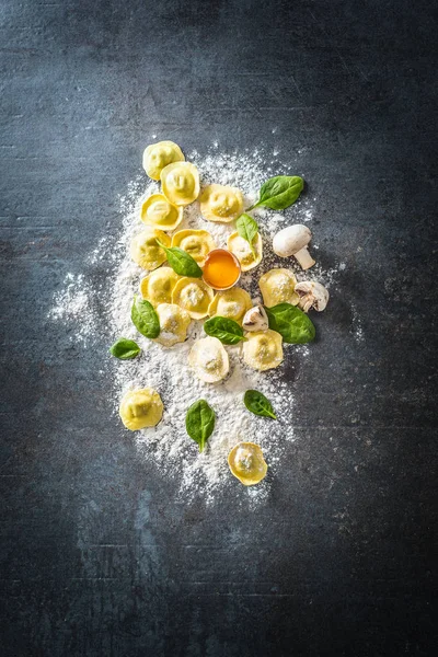 Surowe ravioli z grzybami z mąki i szpinakiem - widok z góry. Włoska lub śródziemnomorska zdrowa kuchnia — Zdjęcie stockowe