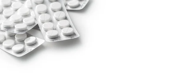 Haufen weißer medizinischer Pillen in Plastikverpackung — Stockfoto