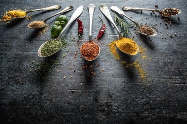 Karanlık arka planda yemek pişirmek için baharatlar ve otlar.