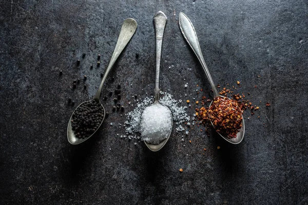 Drie lepels zout chili en zwarte peper. — Stockfoto