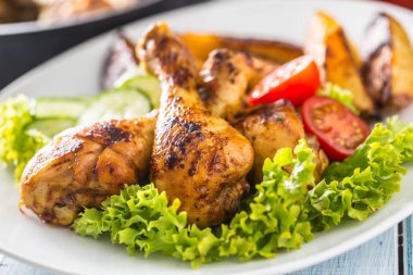 Kızarmış tavuk budu, salata ve domates.