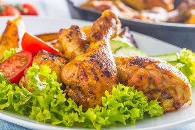 Kızarmış tavuk budu, salata ve domates.