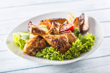 Kızarmış tavuk budu, salata ve domates.