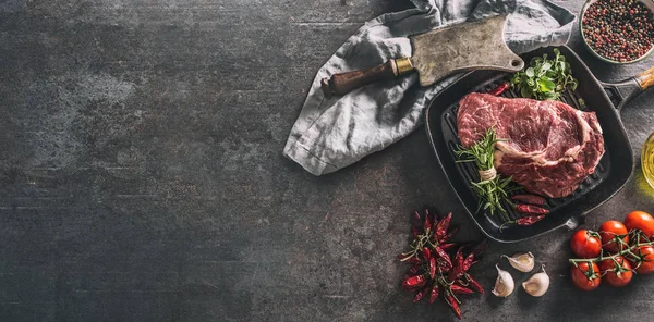 Beef ribe eye steak in grill pan with rosemary oregano salt pepper spices garlic and tomatoes — 图库照片