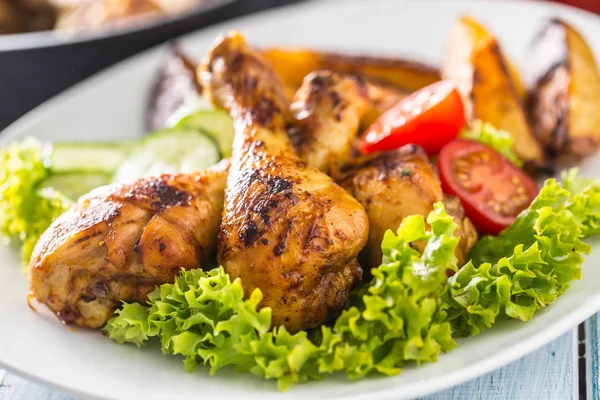 Roasted chicken legs with lettuce salad and tomatoes — Stock Photo, Image