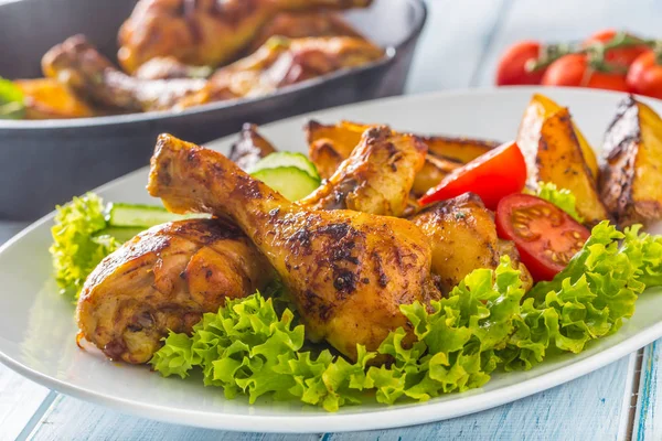 Roasted chicken legs with lettuce salad and tomatoes — Stock Photo, Image