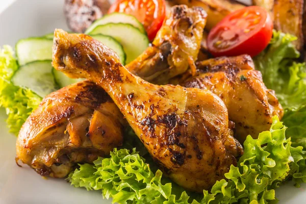 Roasted chicken legs with lettuce salad and tomatoes — Stock Photo, Image