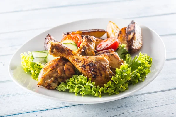 Roasted chicken legs with lettuce salad and tomatoes — Stock Photo, Image
