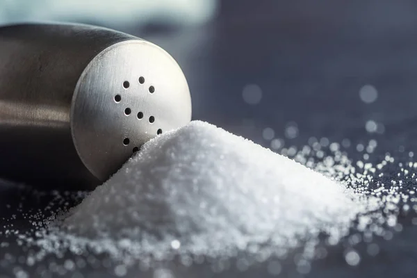 Spillt salt med staniless salt shaker - Närbild — Stockfoto