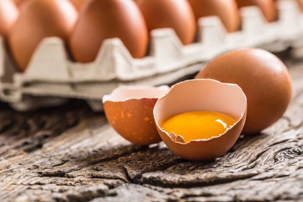 Chicken eggs in carton box on rustic wooden table