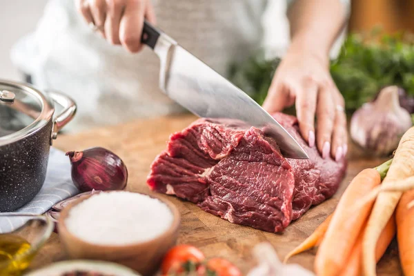 Ung hemmafru skär färskt kött biff. Kvinnliga händer förbereder — Stockfoto