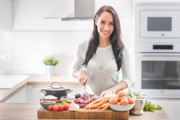 Giovane donna allegra è felice di preparare il pranzo nella sua cucina. S — Foto Stock