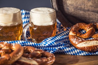 Oktoberfest two beer with pretzel wooden barrel and blue tablecloth