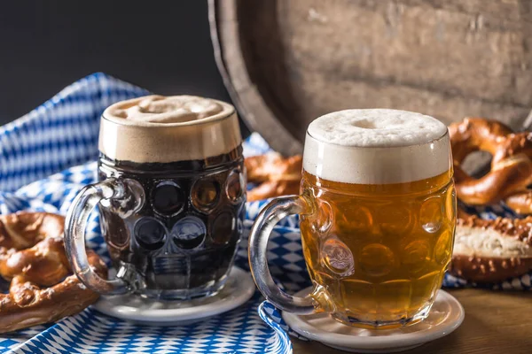 Oktoberfest two beer with pretzel wooden barrel and blue tablecloth — 图库照片