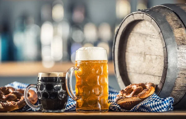 Oktoberfest large and dark beer with pretzel wooden barrel and blue tablecloth — ストック写真