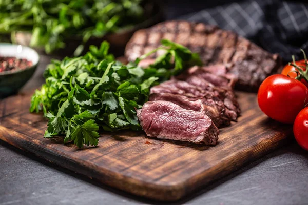 Fatias de bife grelhado suculento em um prato de açougue — Fotografia de Stock