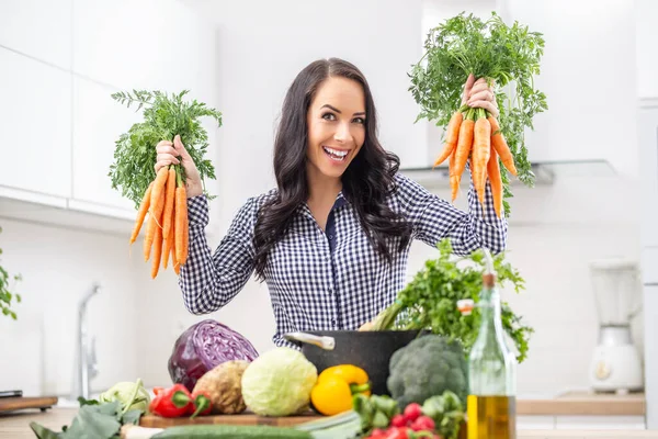 Playful Young Woman Her Kitchen Holding Fresh Carrot Both Hands — Stock fotografie