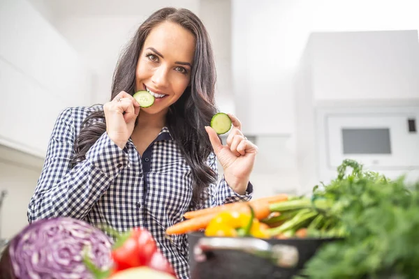 在厨房里拿着几片黄瓜的快乐的年轻女人 饮食蔬菜和健康概念 — 图库照片