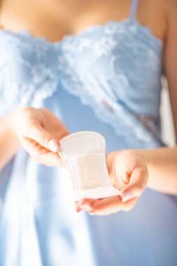 Regl pedi tutan genç bir kadın. Hijyenik peçete ve kadın hijyen konsepti.