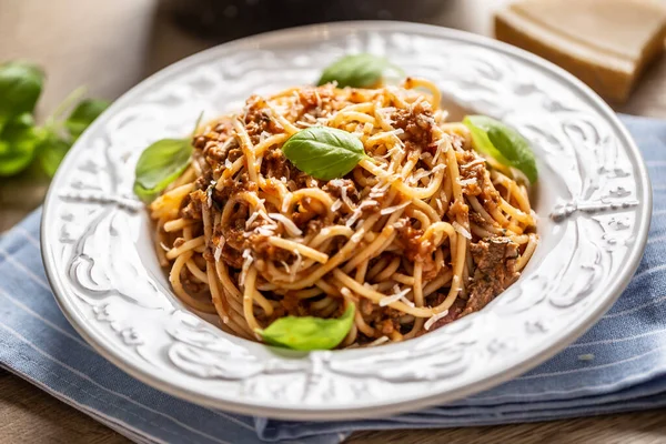 Bolonhesa de macarrão italiano servido em prato branco com queijo parmesão e manjericão — Fotografia de Stock