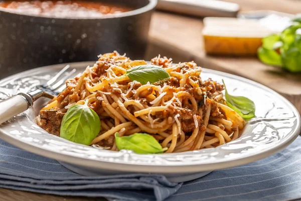 Bolonhesa de macarrão italiano servido em prato branco com queijo parmesão e manjericão — Fotografia de Stock