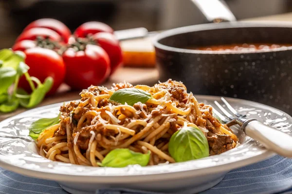 Bolonhesa de macarrão italiano servido em prato branco com queijo parmesão e manjericão — Fotografia de Stock