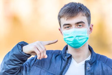 Yüzünde koruyucu maske olan genç bir adam. Virüs tozu ve sise karşı koruma. Coronavirus Covid-19 konsepti.