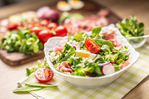 緑の葉と新鮮な春のサラダトマトの卵大根赤玉ねぎ若いエンドウ豆プロシクトフェタチーズとオリーブオイル — ストック写真