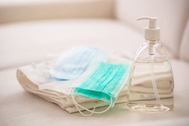Coronavirus önleme konsepti - Cerrahi seyahat maskeleri el dezenfektanı jeli ve havlu.
