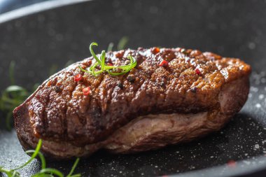 Seramik tavada tuzlu ve biberiyeli ördek göğsü.